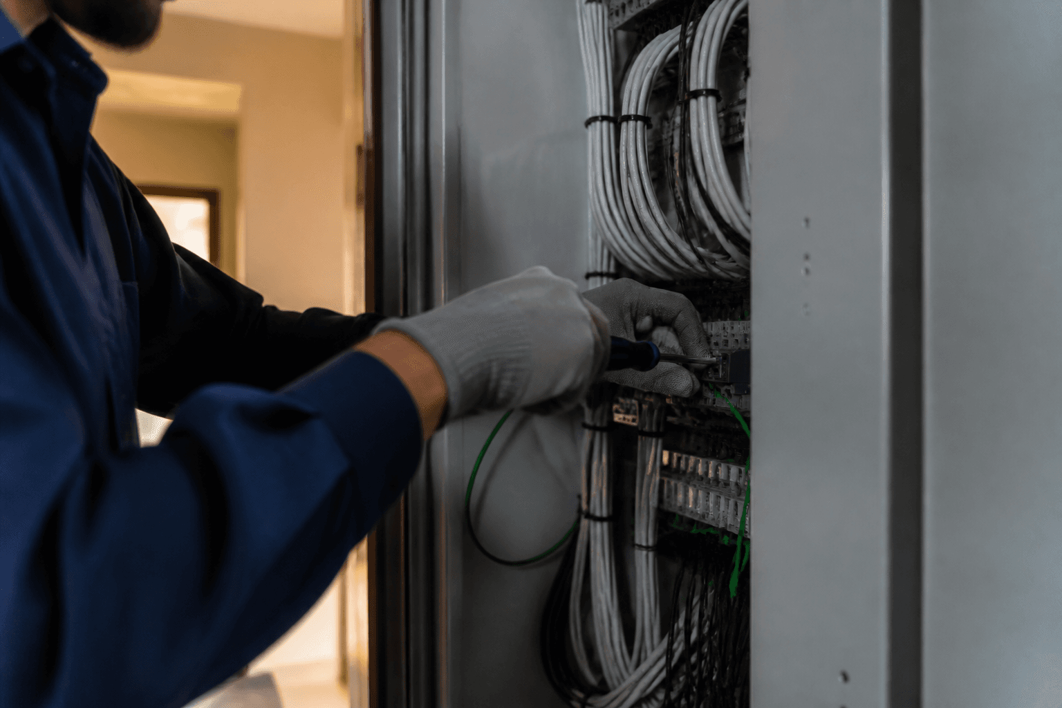 Technician terminating cables in an electrical enclosure