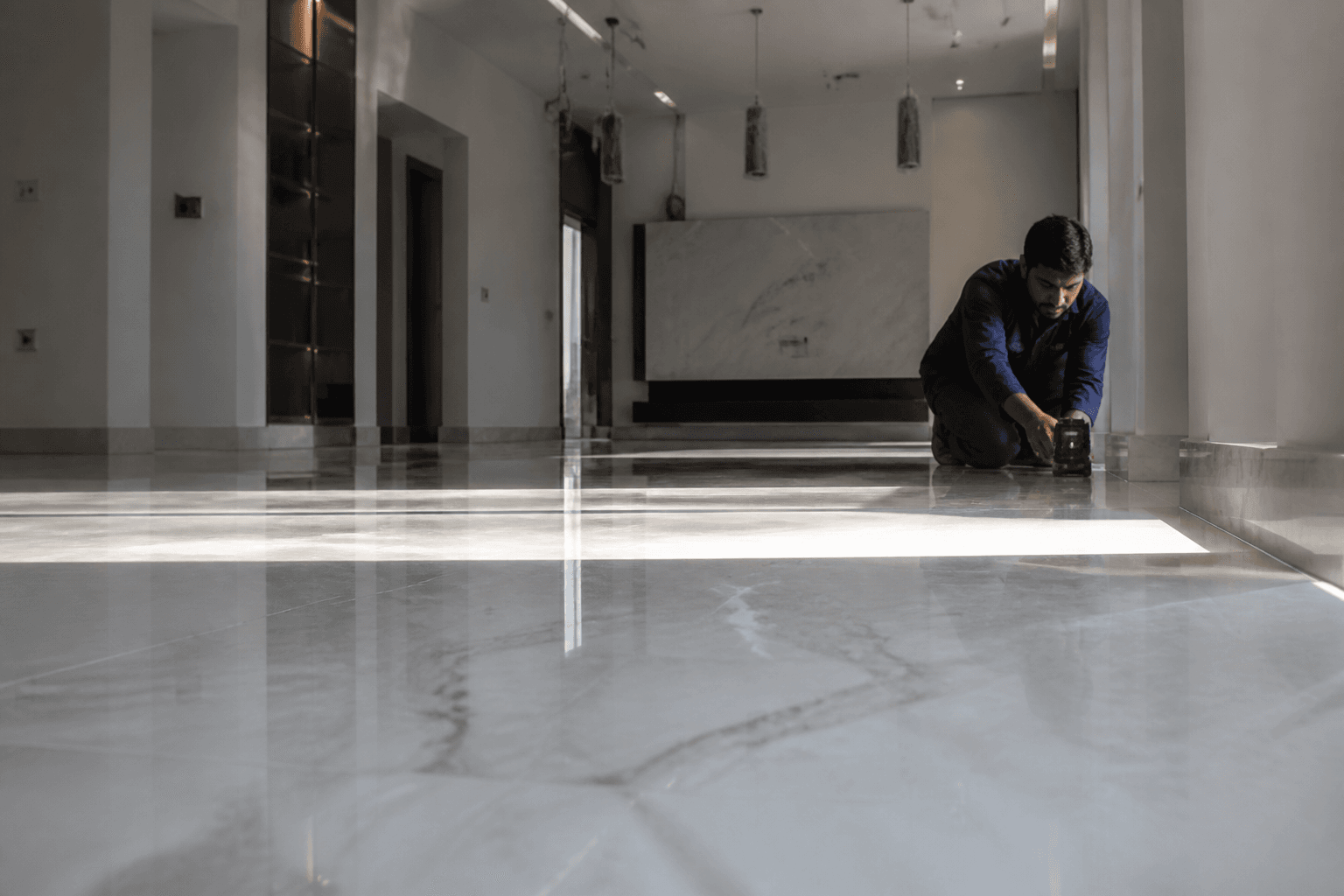 Technician checking a laser level along a newly laid villa floor