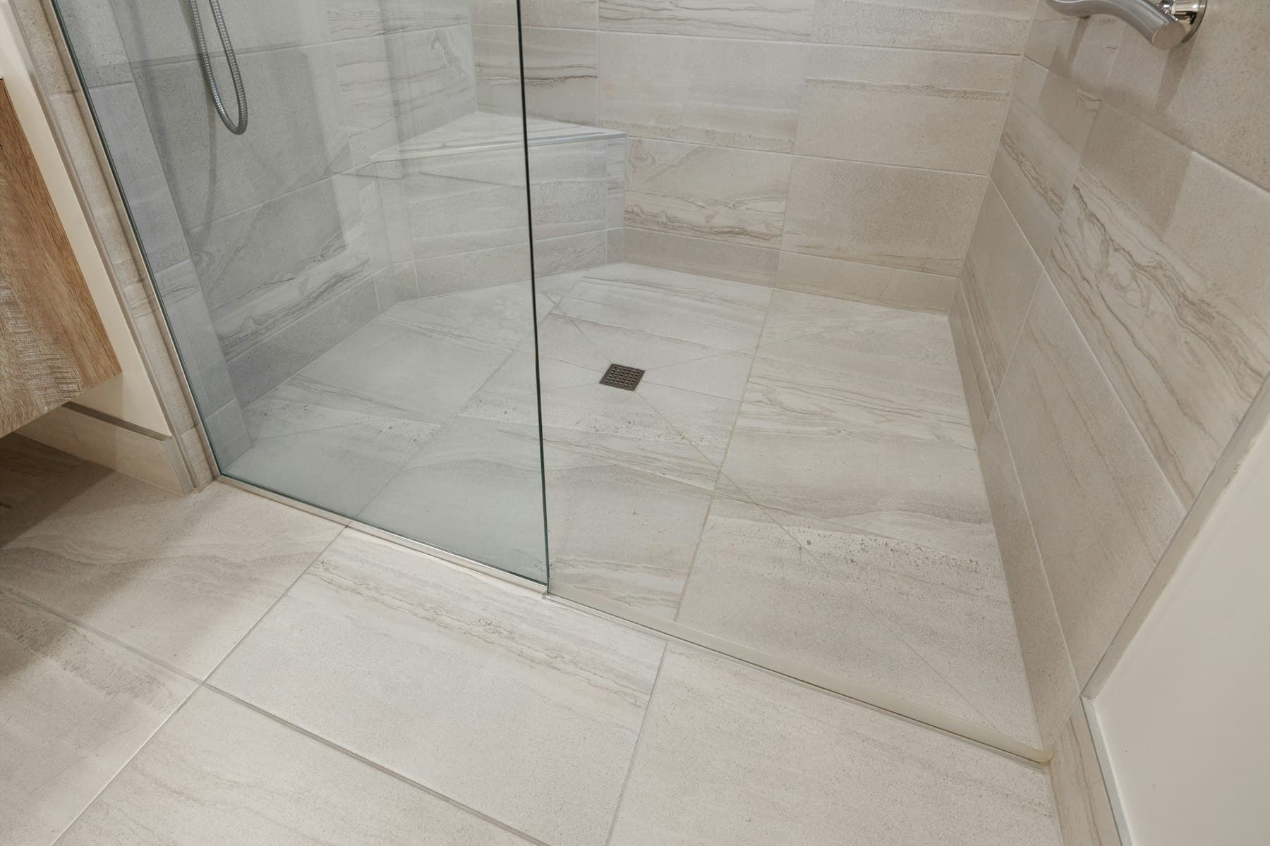 Finished walk-in shower with large-format stone-look wall and floor tiles